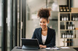 © Nuttapong punna - Young beautiful woman typing on tablet and laptop while sitting at the working  table office
