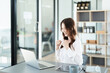 © Jirapong - Portrait of a woman business owner showing a happy smiling face as he has successfully invested her business using computers and financial budget documents at work