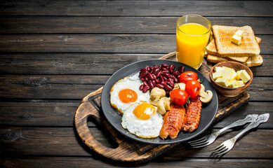 Traditional English Breakfast with fried eggs, sausages and beans.