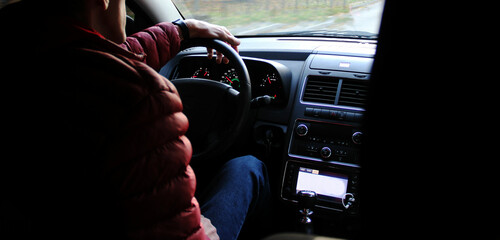 Car dashboard close-up, man driving a car on the road