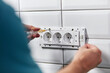 Electrician repairing and fixing wires in the electrical socket.