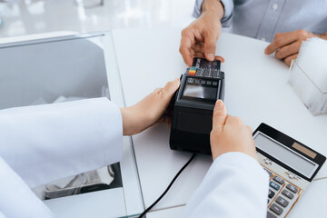 Payment by credit card with payment terminal in qualified drugstore or hospital. Modern payment of electric money. Closeup customer purchase medication in pharmacy with credit card on pos.