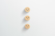 © Worawut - Customer service evaluation and satisfaction survey concepts. Happy face smile face icon on wooden cube, white background
