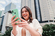 © Jose Calsina - Young caucasian woman smiling searching sale on internet using online shopping app. One happy brunette lady excited using the cellphone. High quality photo