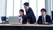 © krongthip - Managers and employees working at desks using laptops to work.