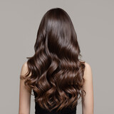 Portrait of a beautiful girl with luxurious curly long hair. Back view.