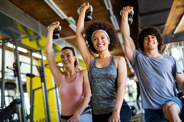 Wall Mural - Multiethnic group of people training in a gym. Trainer and sportive fit persons exercising