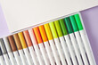 Set of bright watercolor markers for sketching and a sketchbook paper arranged on a table. Drawing and arts hobby theme. Copy space for text