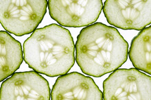 Thin Slices Of Cucumber Lit From Behind, Edges Touching Making A Tiled Pattern.
