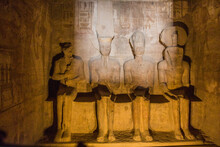 Statues Of Ptah, Amun Ra, King Ramesses II And Ra-Horakhty Illuminated By The Rays Of The Sun In The Great Temple Of Ramesses II  In Abu Simbel, Egypt. This Phenomenon Occurs Only Two Times A Year.