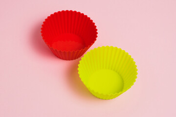 Wall Mural - Red and yellow silicone cupcake molds on a pink paper background