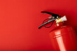 Fire extinguisher on the background of a red wall. Fire protection, home fire extinguisher. home security concept. Place for text. Copy sleep.