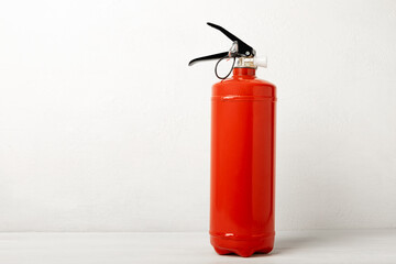 Fire extinguisher on a white texture background. Fire protection, home fire extinguisher. home security concept. Place for text. Copy space.