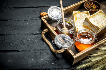 Wall Mural - Different kinds of honey on wooden tray.