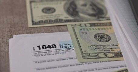 Wall Mural - An American dollar bill, pen calculator and U.S. 1040 individual tax form are placed on desk of American citizen.