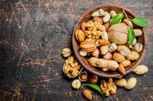 Different Kinds Of Nuts In Bowl With Leaves.