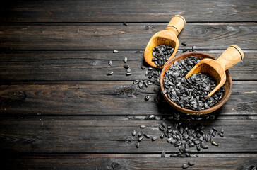 Sunflower seeds in bowl with scoop.