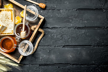 Wall Mural - Different kinds of honey on wooden tray.