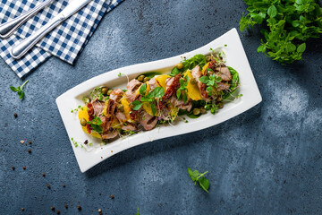 Wall Mural - salad with duck and greens on a white plate top view