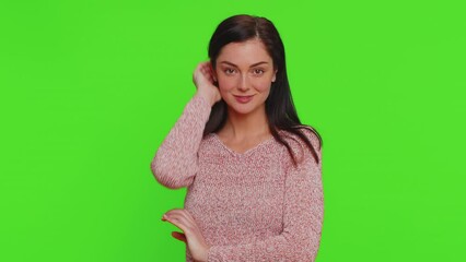smiling playful pretty young woman in sweater blinking eyes, looking at camera with toothy smile, wi