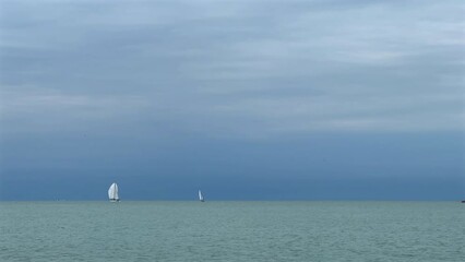 Poster - Sailboats floating on windy seascape over cloudy sky