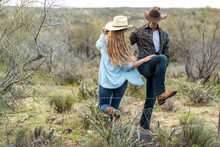 Western Wear Young Couple On Desert Ranch By Barbed Wire Fence