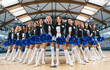 Low-angle shot. Cheerleading V-shaped squad holding blue pom-poms. Sport concept. High quality photo