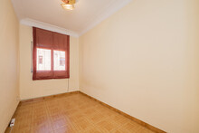 Empty Room With Plain Cream Painted Wall With Tiled Floor And Single Aluminum Window With Semi-transparent Red Blind