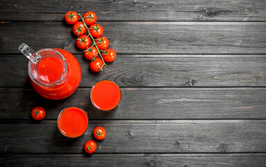 Sticker - Tomato juice in a jug and ripe tomatoes on a branch.