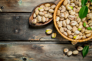 Pistachios in a basket with leaves.