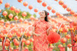 © Piches - Beautiful Asian woman wearing traditional cheongsam qipao dress looking confident holding lantern in Chinese Buddhist temple. Celebrate Chinese lunar new year, festive season holiday. Emotion smile