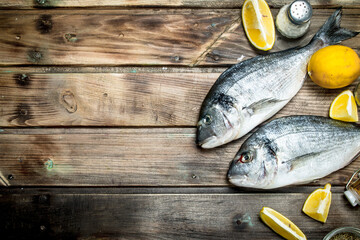 Wall Mural - Raw sea fish with lemon slices and aromatic spices.