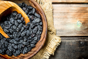 Canvas Print - Raisins in a bowl with a wooden scoop.