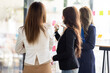 © David - Young creative business Asian woman standing with her colleagues writing new ideas on sticky notes over glass wall, business marketing strategy or User experience ux ui concept.