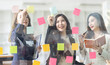 © David - Young creative business Asian woman standing with her colleagues writing new ideas on sticky notes over glass wall, business marketing strategy or User experience ux ui concept.