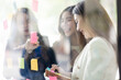 © David - Young creative business Asian woman standing with her colleagues writing new ideas on sticky notes over glass wall, business marketing strategy or User experience ux ui concept.