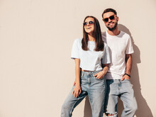 Smiling Beautiful Woman And Her Handsome Boyfriend. Woman In Casual Summer Jeans Clothes. Happy Cheerful Family. Female Having Fun. Sexy Couple Posing In The Street At Sunny Day. Near White Wall