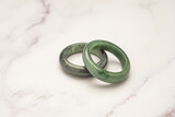 Fototapeta Konie - Green jade rings on a marble table