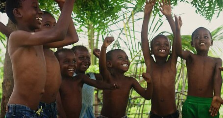 Wall Mural - A Group Of African Children, Laughing, Jumping And Playing in Rural Area. Black Kids Celebrating Life with Joy. Camera Captures Beauty and Essence Of Childhood, Innocence and Purity of Live in Village