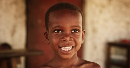 Wall Mural - Close up portrait of a Cute Little African Kid with a Big Beautiful Smile Looking at the Camera. Happy Male Child in a Rural Area Representing Innocence, Peace and Hope. Documentary Footage