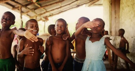 Wall Mural - A Group Of African Children, Laughing, Jumping And Waving in Rural Area. Black Kids Celebrating Life with Joy. Camera Captures Beauty and Essence Of Childhood, Innocence and Purity of Live in Village