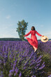 a young woman is running in a lavender field and holding a straw hat