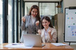© itchaznong - Asian business team happy to be successful partnership teamwork celebrating achievement and success concept. Beautiful business team celebrate with laptop