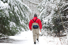 A Man Walks Through The Woods On A Cold, Snowy Winter Day To Go Fly Fishing.