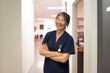 © Austockphoto - female middle aged healthcare worker with arms crossed smiling at the camera
