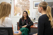 © Austockphoto - smiling female doctor in a clinic with stethoscope around her neck talking to two women