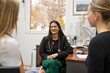 © Austockphoto - smiling female doctor in a clinic with stethoscope around her neck talking to two women