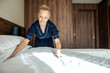 © Dusan Petkovic - A chambermaid is making bed in hotel room.