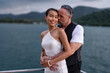 © Tongpool - Romantic couple in love have fun sailing in the sea standing on yacht deck enjoy amazing view