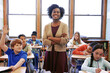 © Reese/peopleimages.com - Portrait, student question and black woman teacher in classroom or middle school. Education, arms crossed or boy raising hand to answer questions, studying or learning help with happy female educator